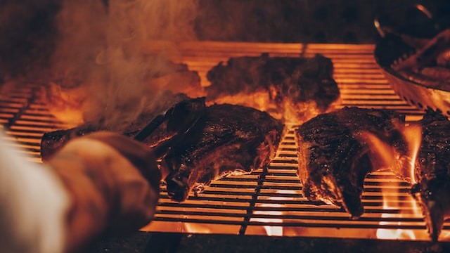 close-up photo of a person grilling meats